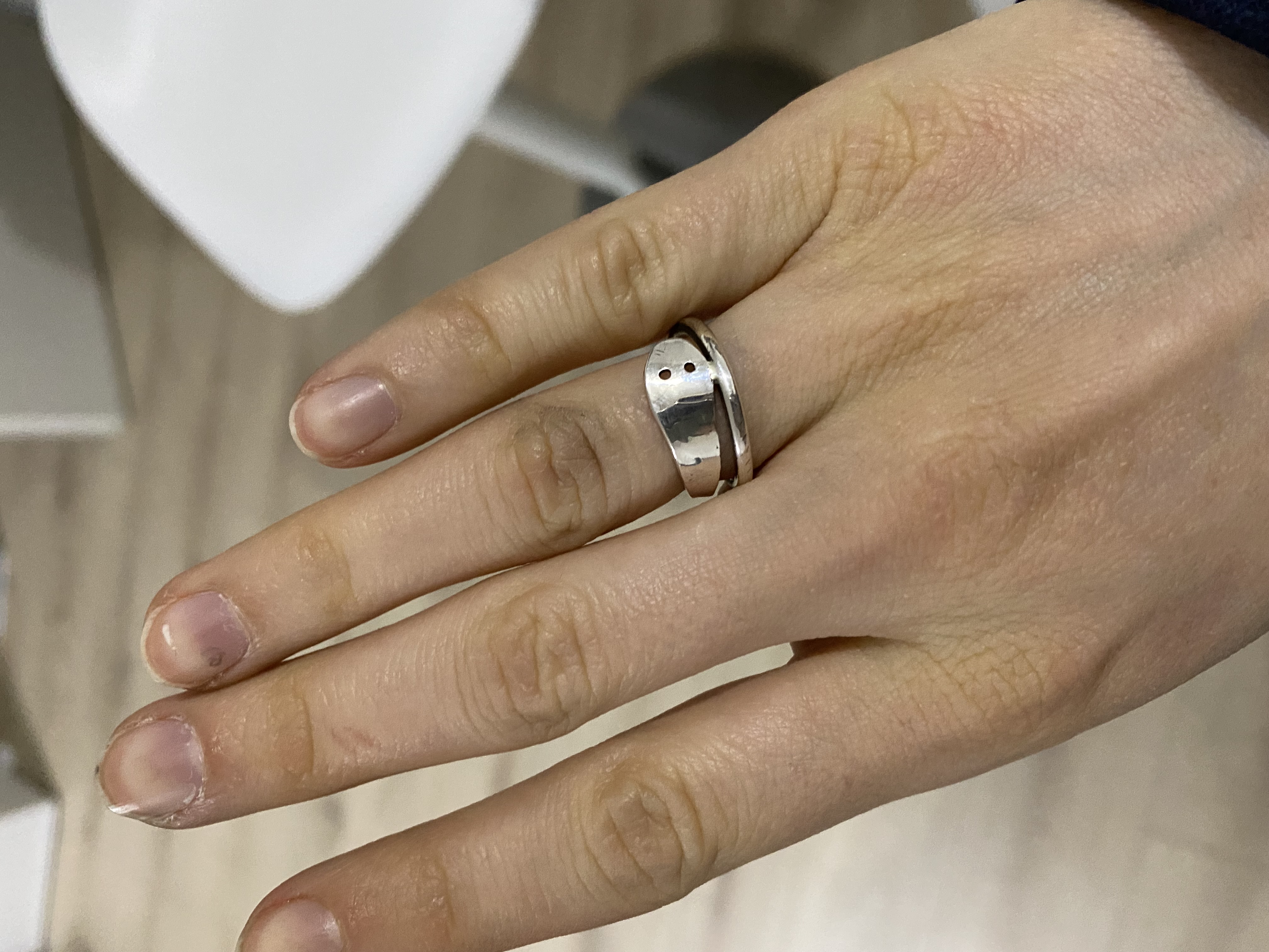 a ring that swirls around the finger like a snake. It has a wider end with two small holes, resembling the snake`s head and eyes